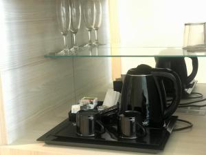 瓦伦西亚Hotel Neptuno Playa & Spa的咖啡壶和柜台上的酒杯