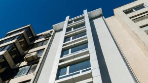 波尔图room Select Porto Suites的公寓大楼面对蓝色的天空