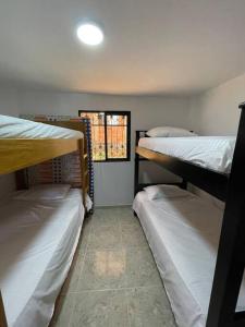 瓜塔佩Linda casa con espectacular vista embalse y piedra的客房设有三张双层床和一扇窗户。