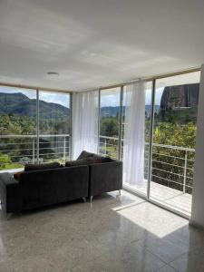 瓜塔佩Linda casa con espectacular vista embalse y piedra的客厅的窗户前设有沙发