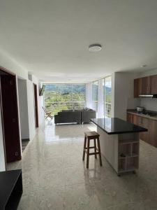 瓜塔佩Linda casa con espectacular vista embalse y piedra的厨房以及带桌子和凳子的客厅。