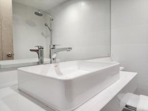 清迈Arsh Boutique Hotel的白色的浴室设有水槽和镜子