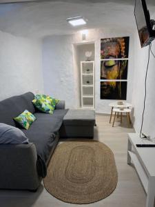 加尔达尔Apartamentos MENBAU的客厅配有灰色的沙发和桌子