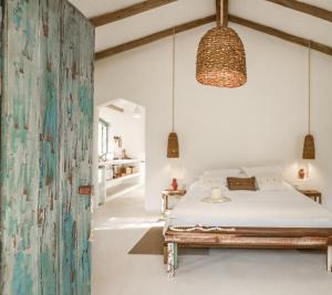 马劳Vila Oyá - praia de algodões的一间卧室配有一张床和一个挂灯