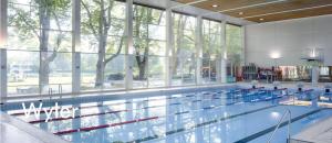 伯尔尼Evi's Home Hotel & Apartments的大型游泳池设有大窗户