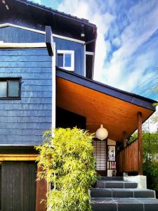 由布市旅館 竹屋 Takeya的前面有蓝色屋顶和楼梯的房子