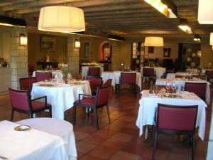阿伊诺阿Hotel Argi Eder的用餐室配有白色的桌子和红色的椅子
