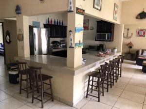蒙特里科Casa Los Cocos Monterrico的一间厨房,内设一个带凳子的大柜台
