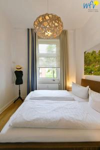 于斯德Haus Inselrose Ferienwohnung Wildrose的卧室内的一张大白色床,带有窗户