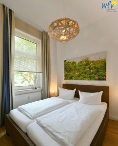 于斯德Haus Inselrose Ferienwohnung Wildrose的卧室设有一张白色大床和一扇窗户。
