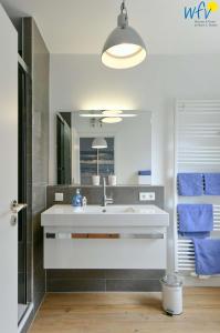 于斯德Haus Inselrose Ferienwohnung Wildrose的一间带水槽和镜子的浴室