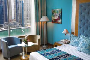 迪拜玛立纳比布鲁斯酒店的酒店的客房 - 带一张床、椅子和窗户