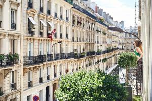 巴黎快乐文化塞万提斯酒店的站在建筑物前阳台的女人