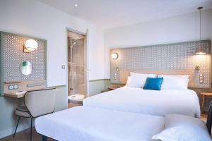 巴黎快乐文化塞万提斯酒店的酒店客房设有两张床和电视。
