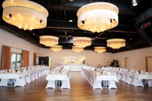 Neuhausen ob EckAircraft Hotel & Events的宴会厅配有白色的桌椅和吊灯