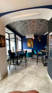 圣阿芒蒙特龙Hotel restaurant LA PLACE的一间配备有桌椅的用餐室和蓝色的墙壁