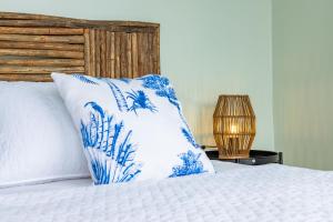卡塔赫纳Fragata Island House的一张带蓝色和白色枕头的床和一盏灯