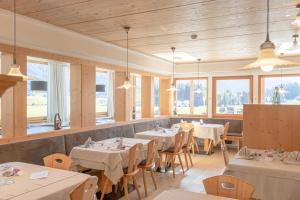 瓦莱迪卡谢斯蒂罗尔酒店的餐厅设有白色的桌椅和窗户。