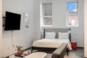 安娜堡Exhibit A2的一间卧室配有一张床和一台平面电视