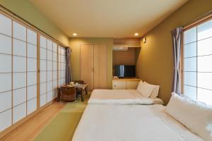 大阪俪居花园酒店Reikyo Garden Hotel的酒店客房设有两张床和窗户。