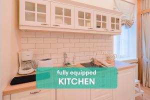 塔林梦未顿塔林的厨房配有白色橱柜和厨房标志,厨房标志配有设备齐全的厨房。