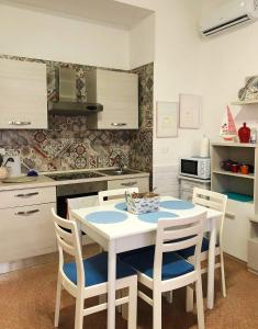 托雷斯佩基亚鲁杰里Villa Martina fronte mare - Litoranea San Foca Torre Specchia Ruggeri的厨房配有白色的桌椅