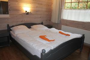 温特斯韦克Chalet Nieuw Beusink的一间卧室配有带橙色毛巾的床