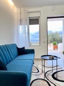 纳夫普利翁ενtreé guest house near Palamidi Castle的客厅配有蓝色的沙发和桌子