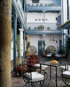 塞维利亚Hospes Las Casas Del Rey De Baeza, Seville, a Member of Design Hotels的大楼内带桌椅的庭院