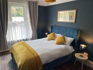 凯尔西温TW O Connell old world Irish pub的蓝色卧室配有一张带黄色枕头的大床