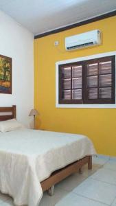 伊利亚贝拉Chalés Azuleto - Ilhabela的一间卧室配有一张床,窗户配有空调