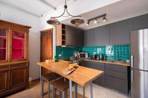 卡利亚里Domus De Gorga - Your Sardinian Apartment的厨房配有木桌和冰箱。