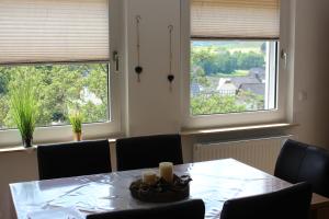 巴特拉斯费Ferienwohnung Am Sonnenhang Blecher的一间带桌子和2个窗户的用餐室