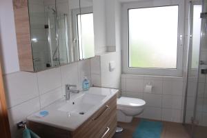 巴特拉斯费Ferienwohnung Am Sonnenhang Blecher的一间带水槽和卫生间的浴室以及窗户。