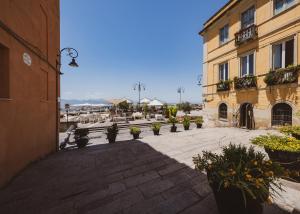 卡利亚里Domus De Gorga - Your Sardinian Apartment的一座带桌子和盆栽植物的建筑的庭院