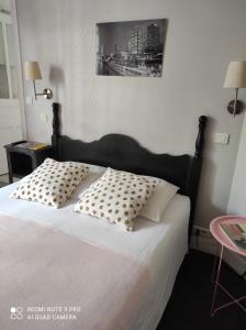 巴黎魏尔伦酒店的一间卧室配有一张带两个枕头的床