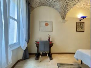 萨罗Casa Collini Salò的客房设有桌子、椅子和窗户。