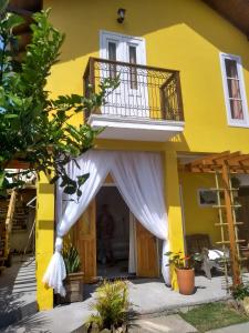 皮涅拉Vila Sabará的门上方的黄色房子,有白色窗帘