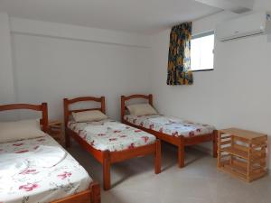 萨尔瓦多Casarão Nazaré Hostel的带三张床和窗户的客房
