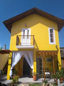 皮涅拉Vila Sabará的带阳台的黄色房屋