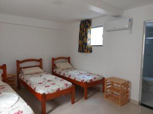 萨尔瓦多Casarão Nazaré Hostel的客房设有两张单人床和一扇窗户。