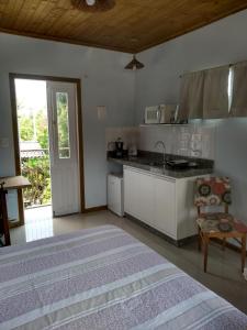 皮涅拉Vila Sabará的一间卧室配有一张床,厨房配有水槽