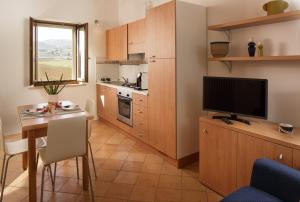 卡纳拉SeiPetali的一间小厨房,内设桌子和一台电视机