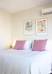 布宜诺斯艾利斯Recoleta Apartment Amazing view -13A-的卧室配有一张带紫色枕头的大型白色床。