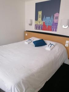布鲁瓦Kyriad Blois Nord的一张白色的床,上面有蓝色的枕头