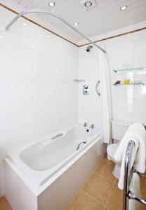 圣马丁格恩西La Villette Hotel的白色的浴室设有浴缸和卫生间。