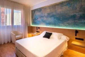 巴古尔Hotel Rosa & Spa Begur的卧室配有一张床,墙上挂着一幅大画