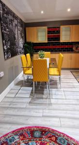 Coundon4 bedroom House Coventry Sleep 9 + 3Parking spaces的一间带桌子和黄色椅子的用餐室