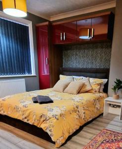 Coundon4 bedroom House Coventry Sleep 9 + 3Parking spaces的一间卧室配有一张黄色棉被的床
