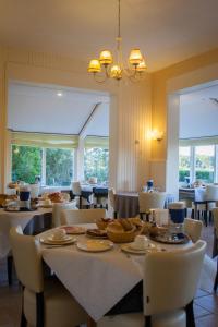 内斯森林与沙丘景观酒店的一间带桌椅和窗户的用餐室
